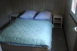 a bedroom with a bed with blue sheets and pillows at Chalet Sorgenfri in Durbuy +21 photos