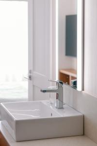 a white sink in a bathroom with a mirror at Boston Plaza Kusatsu Biwa Lake - Vacation STAY 15460v in Kusatsu +2 photos