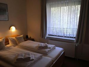 a bedroom with two beds with towels and a window at Schwertlilie in Wittdün