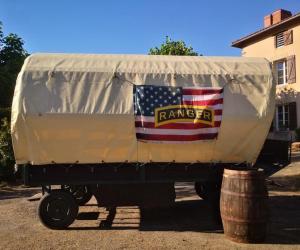 a trailer with an american flag on it with a barrel at Clos de l'Isop, le village d'hébergements insolites in Saint-Martial-sur-Isop