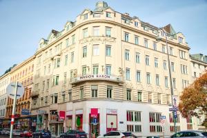 a building on a street with cars parked in front of it at Hotel Pension Baron am Schottentor in Vienna