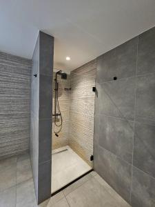 a bathroom with a shower with a glass door at L' Gante in Ghent