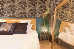 a bedroom with a bed with a mirror and a wall at Suite avec jacuzzi - Le Boudoir de la Loire in Chalonnes-sur-Loire