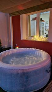 a large bath tub in a room with windows at Cosy home D&D in Brod Moravice