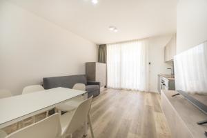 eine Küche und ein Wohnzimmer mit Tisch und Stühlen in der Unterkunft Wave Island A18 in Lido di Jesolo