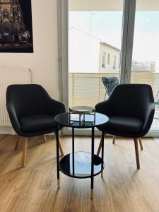 two chairs and a table in a room at Bleuets studio cosy neuf terrasse proche centre in Reims