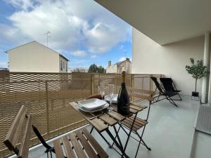 a table with a bottle of wine on a balcony at Bleuets studio cosy neuf terrasse proche centre in Reims