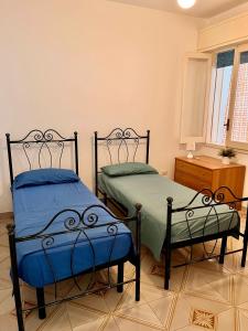 a bedroom with two beds and a dresser at House on the beach in Lido Marini
