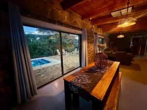 a living room with a table and a large window at Athule Inn - Cradle in Hekpoort