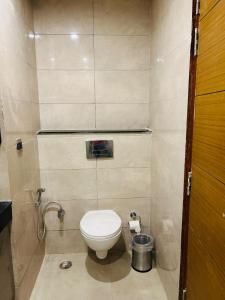 a small bathroom with a toilet in a stall at Red Wood Vacation Homes-Omaxe Hazratganj in Lucknow