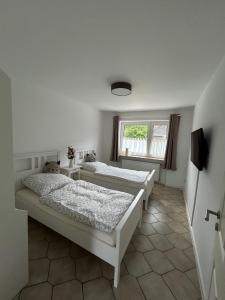 two beds in a room with a window at Ferienwohnung Familie Reiprich in Bremerhaven