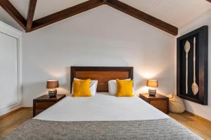 a bedroom with a large bed with yellow pillows at Kuanza Nature Experience, Fajã do Belo in Fajã da Caldeira de Santo Cristo