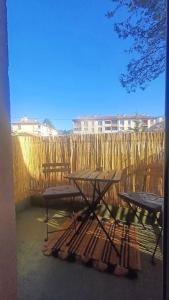 eine Gruppe Picknicktische vor einem Zaun in der Unterkunft Le Colibri - studio paisible et raffiné au sud d'Aix in Aix-en-Provence