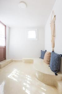 un soggiorno con divano su un pavimento in cemento di Villa Plaka 16 - 'The Cave' - Drepano, Nafplio a Drepano