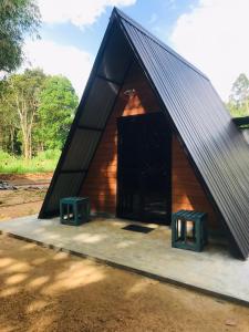 a small house with two stools in front of it at Pahiyan Huts by Luxuryexperience. in Bulatsinhala