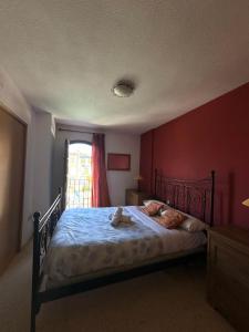a bedroom with a bed with a red wall at Port Saplaya 2 habitaciones Valencia in Port Saplaya +17 photos