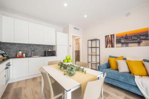 eine Küche und ein Wohnzimmer mit einem Tisch und einem blauen Sofa in der Unterkunft Wave Island H2 in Lido di Jesolo