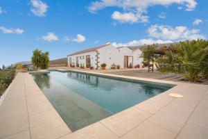 a swimming pool in front of a house at Casa del Cielo in Adeje