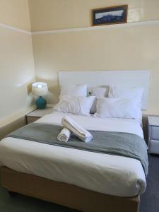 a bed with two towels on top of it at Faranie Guesthouse in Oudtshoorn