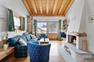 a living room with a blue couch and a fireplace at Luxury Chalet St Moritz with View - 4 Bedrooms in Madulain