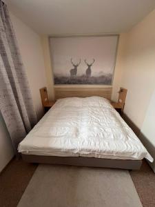 a bedroom with a bed with a painting of deer on the wall at Exklusive Mini Suite - Panorama Hohegeiß in Braunlage +22 photos