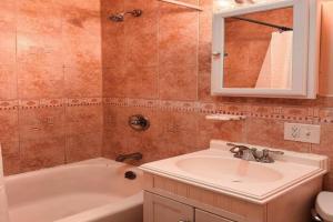 a bathroom with a sink and a tub and a mirror at NY - NJ Tennis Suites - Sleeps 40 - 15 Mins to NYC in Union City +84 photos