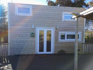 a house with a white door and windows at The Wee Tiny Home in Derry Londonderry