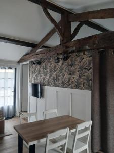 a dining room with a wooden table and white chairs at Gîte Héloïse in Le Pallet +11 photos