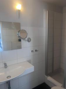 a bathroom with a shower and a sink and a mirror at MiLANO Seehotel in Krakow am See