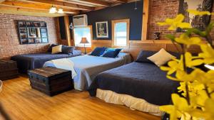 a bedroom with two beds and a brick wall at Triple See NY Now - Sleeps 41 -15 Mins to NYC in Union City