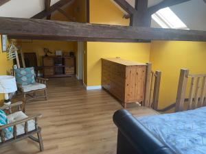 a bedroom with yellow walls and a bed and a dresser at Ye Old Sun Inn, Barn Studio in Bilbrough