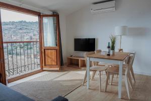 a living room with a table and chairs and a television at Apartamentos Destino Alquézar in Alquézar