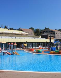 een groot zwembad met kleurrijke vlotten en parasols bij Apartman PETRA ZABOK in Zabok
