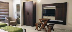 a living room with a tv and a couch and a table at Sharp Suites in Cochin