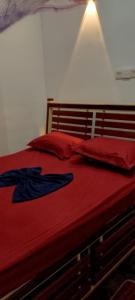 a red bed with red sheets and red pillows at Mandara Villa Hiriketiya in Dickwella