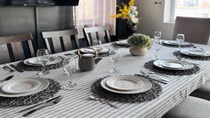 a table with plates and wine glasses on it at Mega See NY Now - Midtown - Apt 1 & 2 Combo in Union City