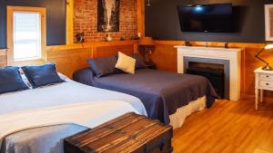 a bedroom with two beds and a tv and a fireplace at Mega See NY Now - Midtown - Apt 1 & 2 Combo in Union City