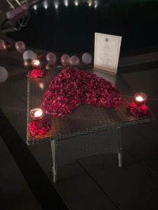 a table with a bunch of roses and candles at Ritz Resort Lucknow- The Perfect Blend of Business and Leisure in Lucknow
