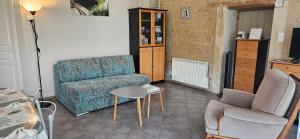 a living room with a chair and a table at les 2 Gîtes du Clos de la Vigne in Montreuil