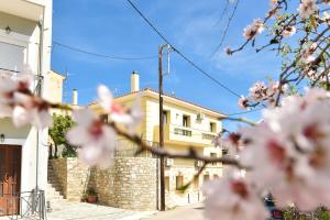 a building with white flowers in front of it at Kentos Charming Stone Escape Near Fishing Harbor in Katarráktis
