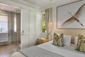 un dormitorio con una cama con un pájaro volando sobre ella en Knysna - Cycad Cottage, en Knysna 21 fotos más