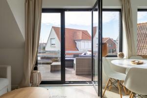 a living room with a large sliding glass door at The Ocean Breeze 1 in De Haan