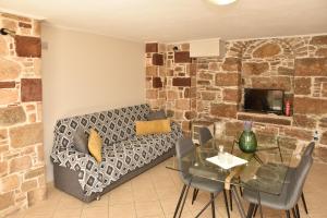 a living room with a couch and a table at Kentos Charming Stone Escape Near Fishing Harbor in Katarráktis