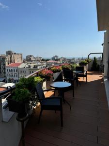 ein Balkon mit Tischen und Stühlen und Blick auf eine Stadt in der Unterkunft Guci Hotel in Constanţa