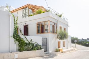 a white house with plants on top of it at Two beautiful rooms & 1 large Patio in Drepana