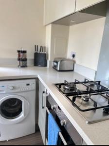 una cocina con estufa y lavadora en New Build Luxury Home in Ashford, en Willesborough