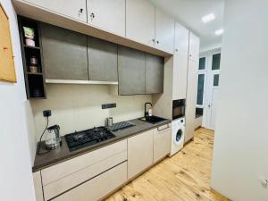 a kitchen with white cabinets and a stove top oven at Apartment with Workspace and TV in Nový Lískovec