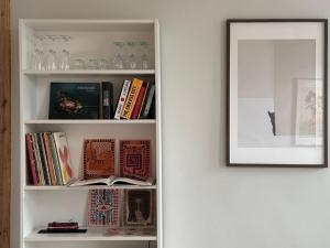 a book shelf with books and a picture on it at Stepono Apartment in Vilnius
