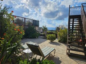 a patio with a chair and a staircase and flowers at HideAway Lasa in Lasa