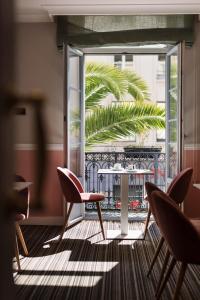 a room with a balcony with chairs and a table at Best Western Hotel Lakmi Nice in Nice